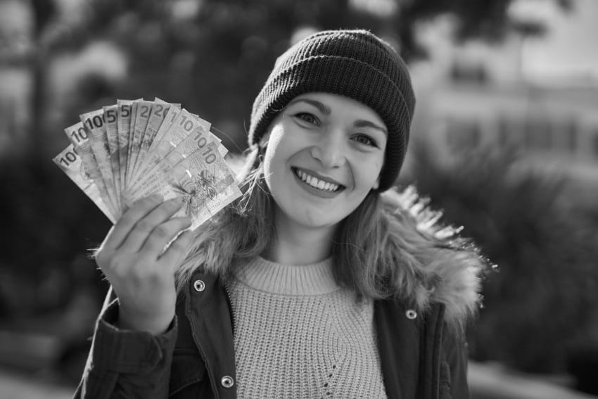 finansisjki horoskop mart 2026. devojka drži novčanice