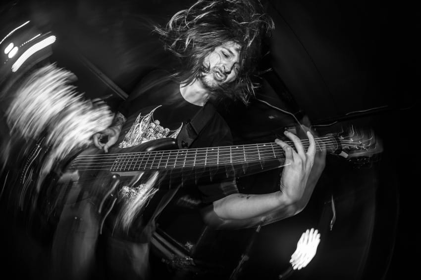 Gitarista u zanosu svira na koncertu – energija rok i metal muzike uživo