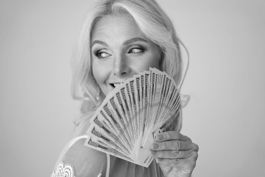 Finansijski horoskop maj 2026. žena drži novčanice
