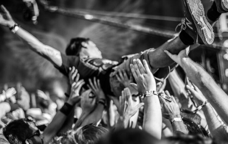 Crowd surfing i hardcore atmosfera na alternativnom punk festivalu ilustracija za Mighty Sounds 2026.