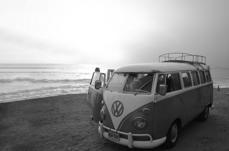 Volkswagen Bus parkiran pored mora – simbol kontrakulture, putovanja i slobodnog duha