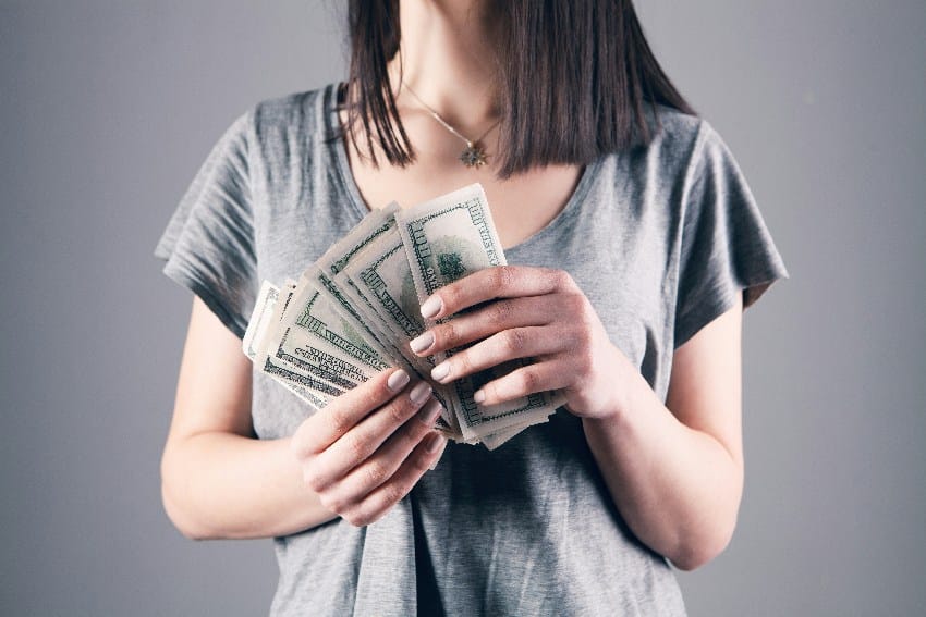 finansijski horoskop devojka drži novčanice