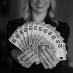finansijski horoskop devojka drži hrpu novčanica