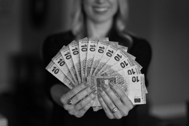 finansijski horoskop devojka drži hrpu novčanica