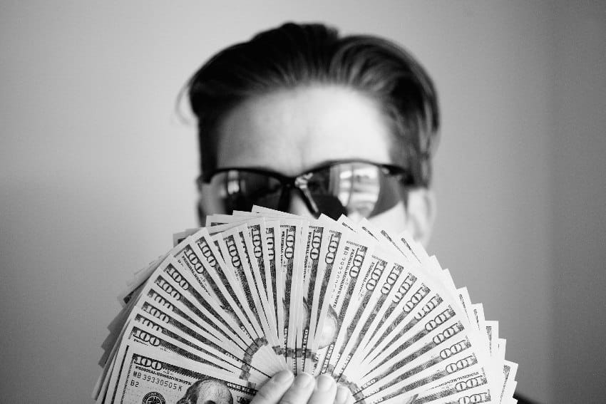 finansijski horoskop muškarac drži hrpu novčanica