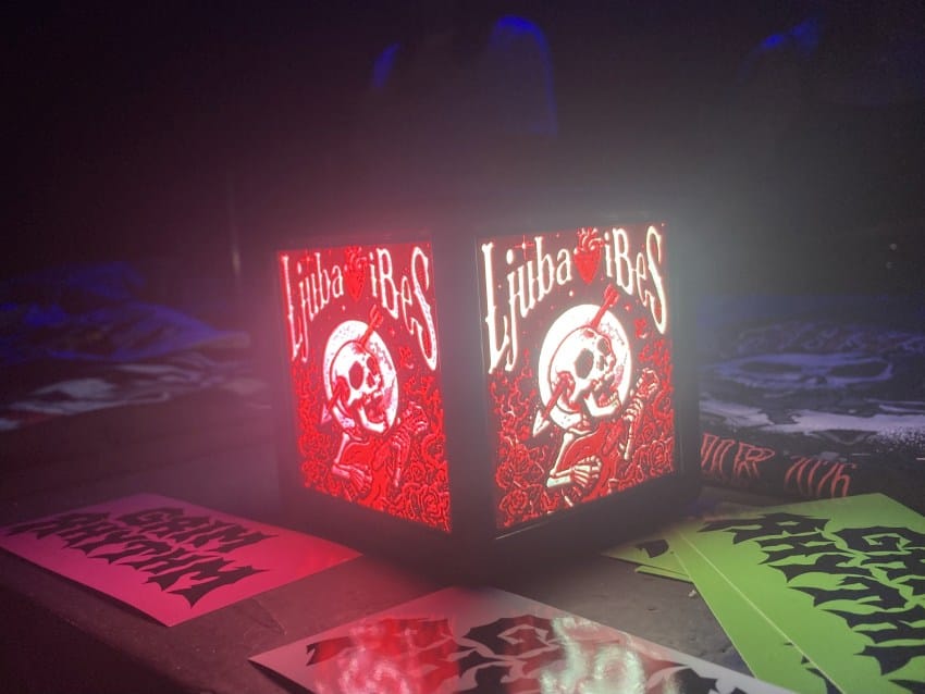 Logo festivala Ljubav i Bes kocka koja svetli na merch štandu